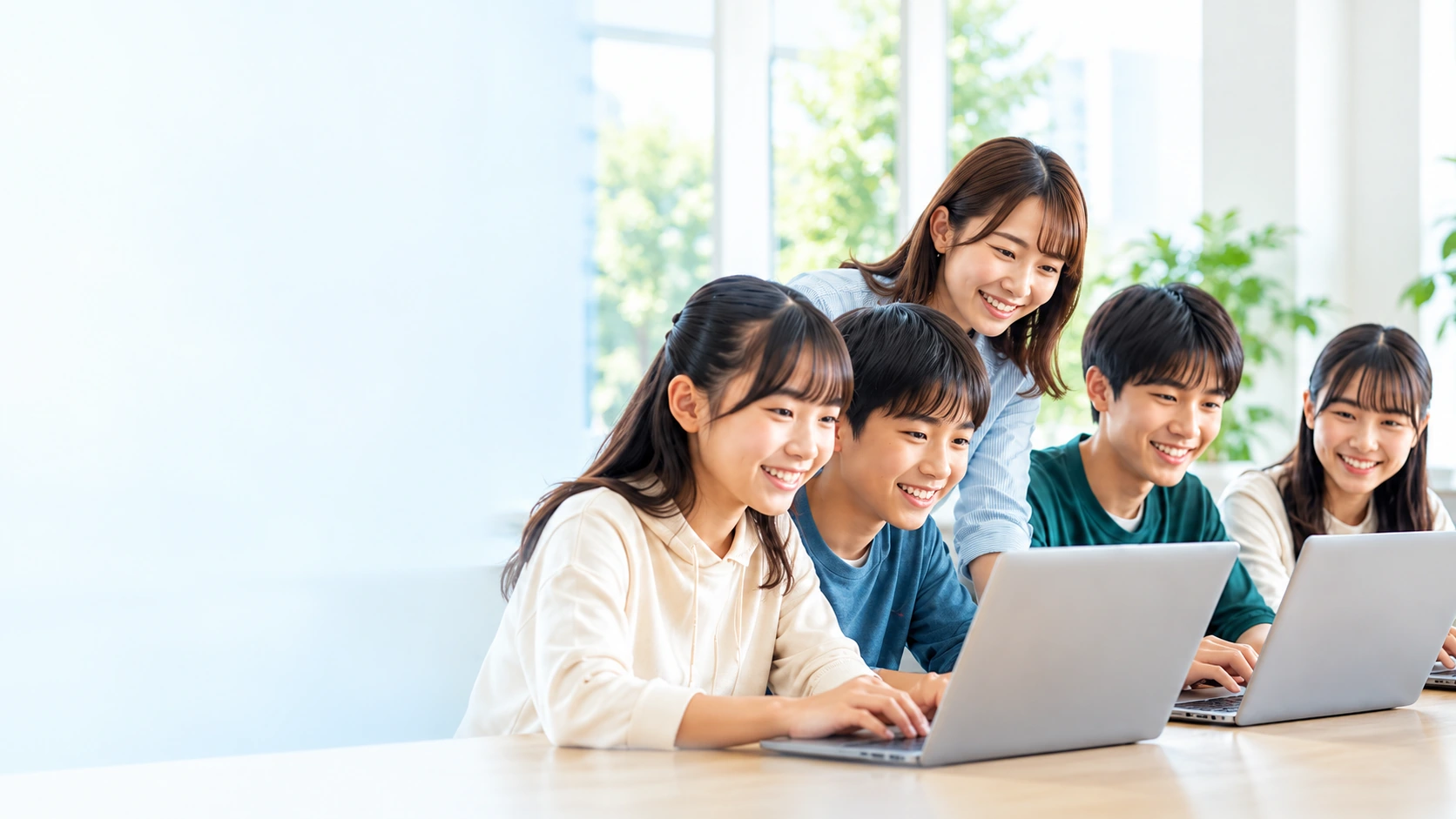 ノートパソコンで一緒に学ぶ学生と講師のグループ